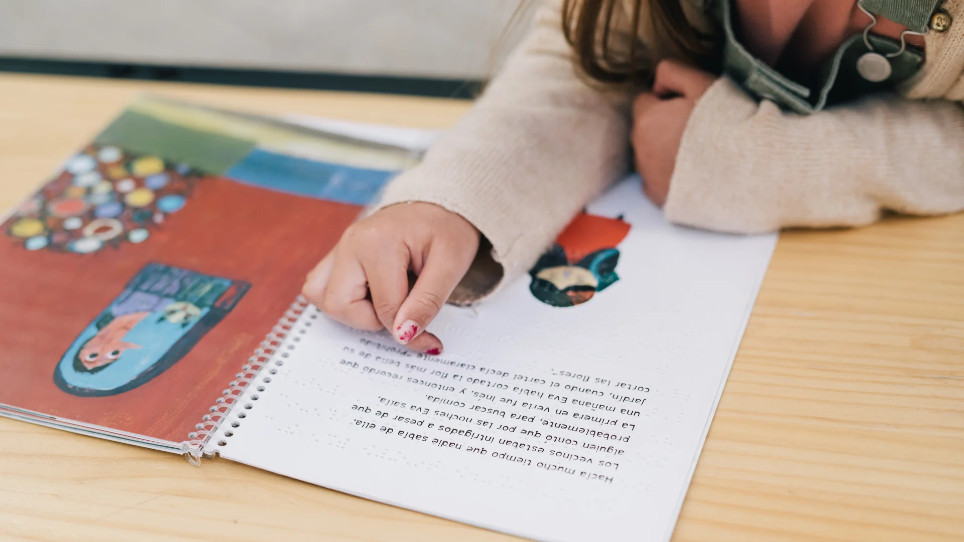 Little girl reading a braille book