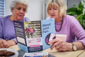 two senior women reading an about health leaflet titled about joint pain