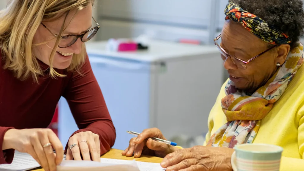 Two people looking at print media in a healthcare space
