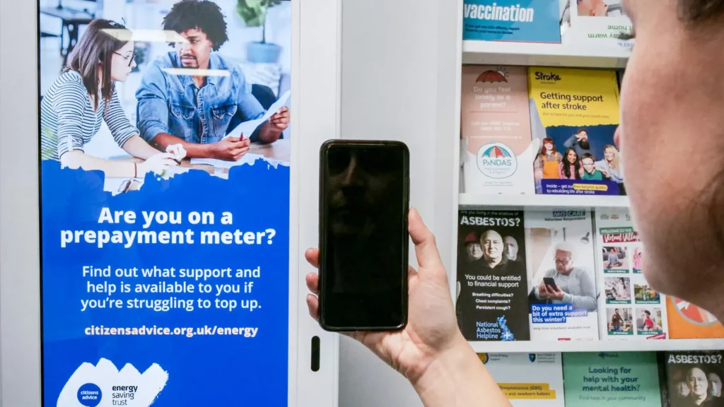 Woman holding a phone in front of a digital screen